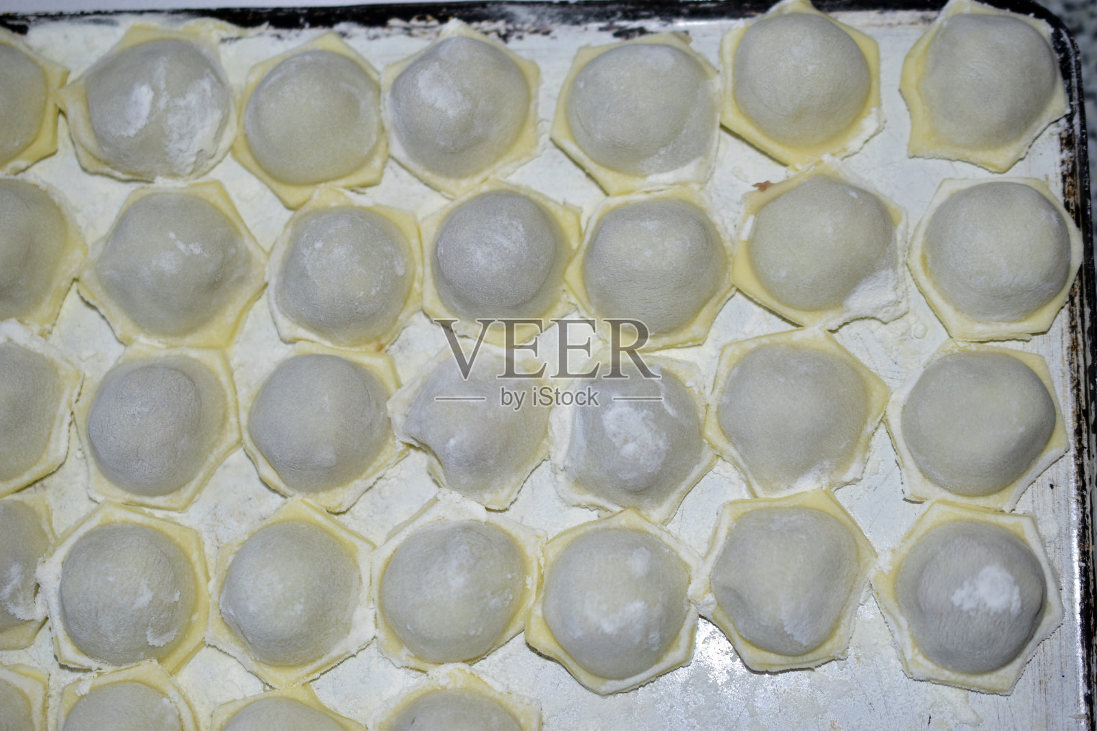 在白色的烤盘上做肉馅饺子照片摄影图片