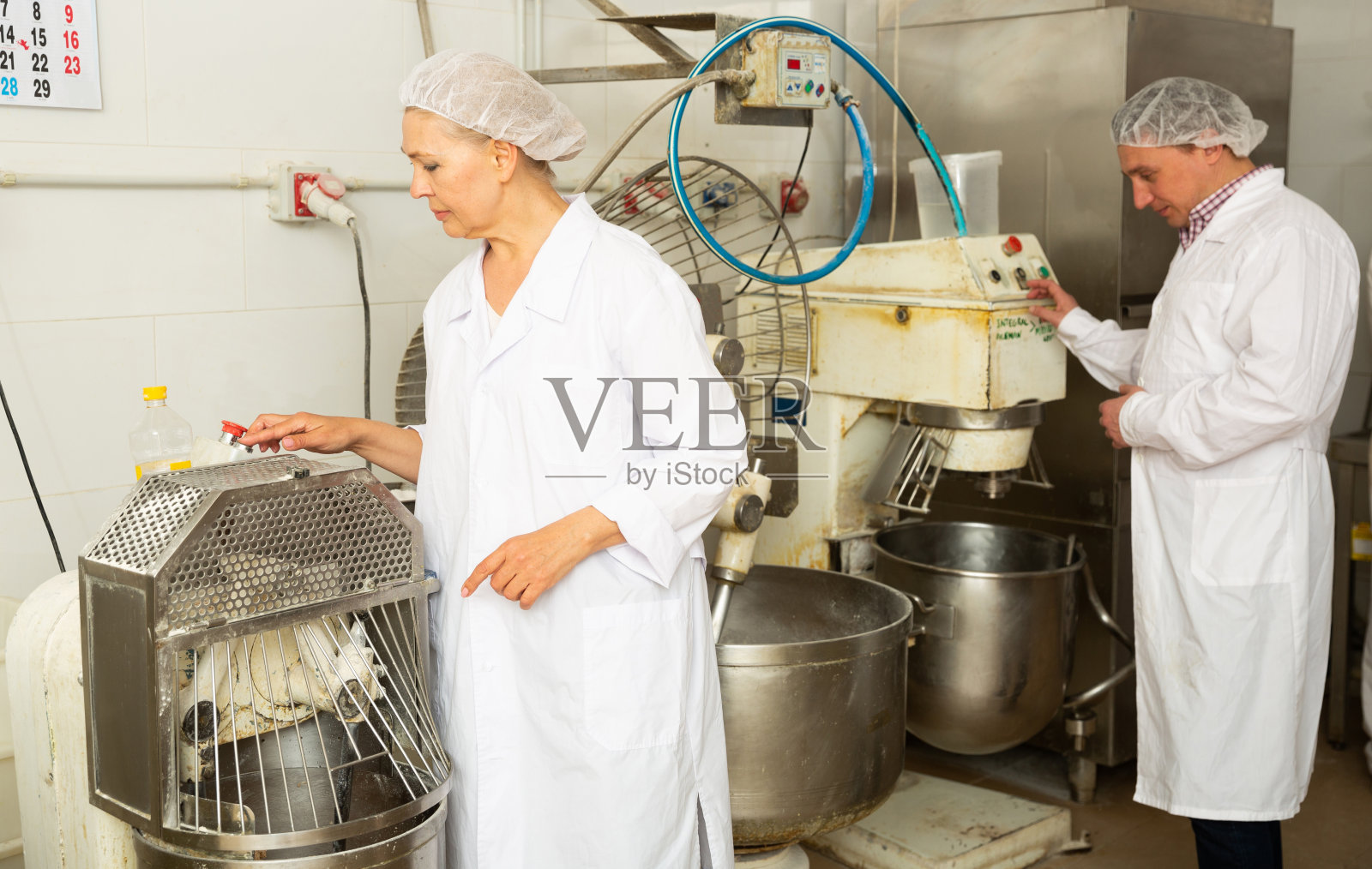 厨师和面包师在电动搅拌机中准备生面团照片摄影图片