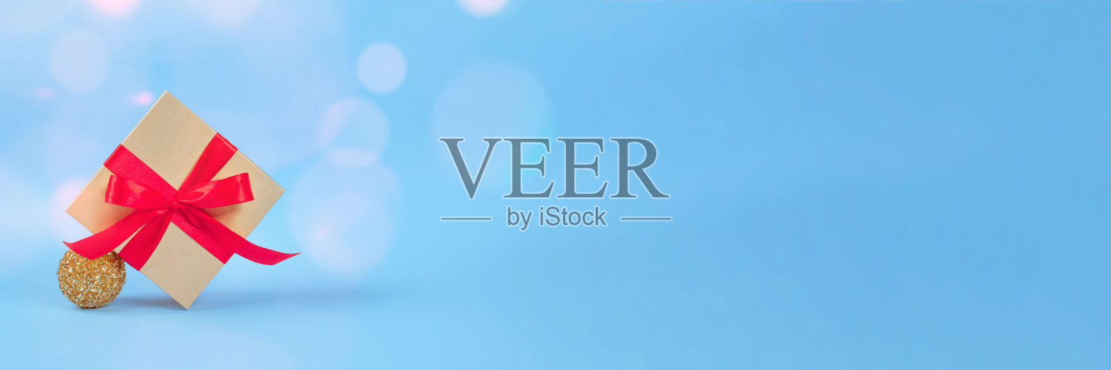 横幅与礼物盒与红色的弓和圣诞树装饰在节日蓝色背景与模糊散焦和copyspace为您的文本。圣诞节或新年庆祝概念照片摄影图片