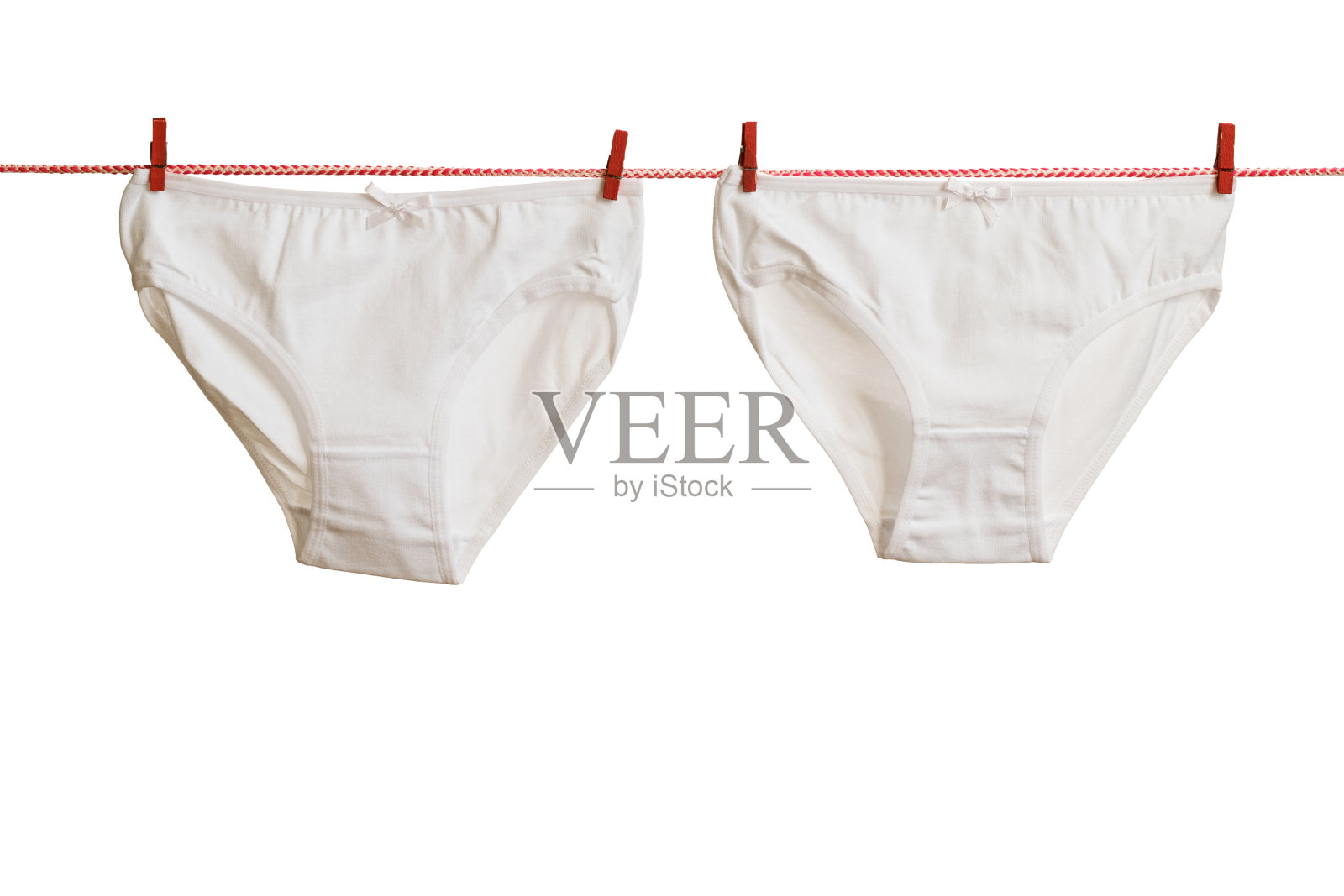 白色内裤系在红白相间的绳子上，还有红色的衣夹。照片摄影图片