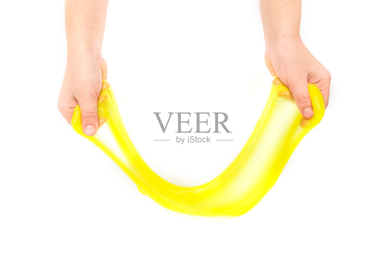 现代玩具叫做黏液。孩子玩透明的黄色黏液。双手拿着一个粘液孤立在一个白色背景。有选择性的重点。照片摄影图片