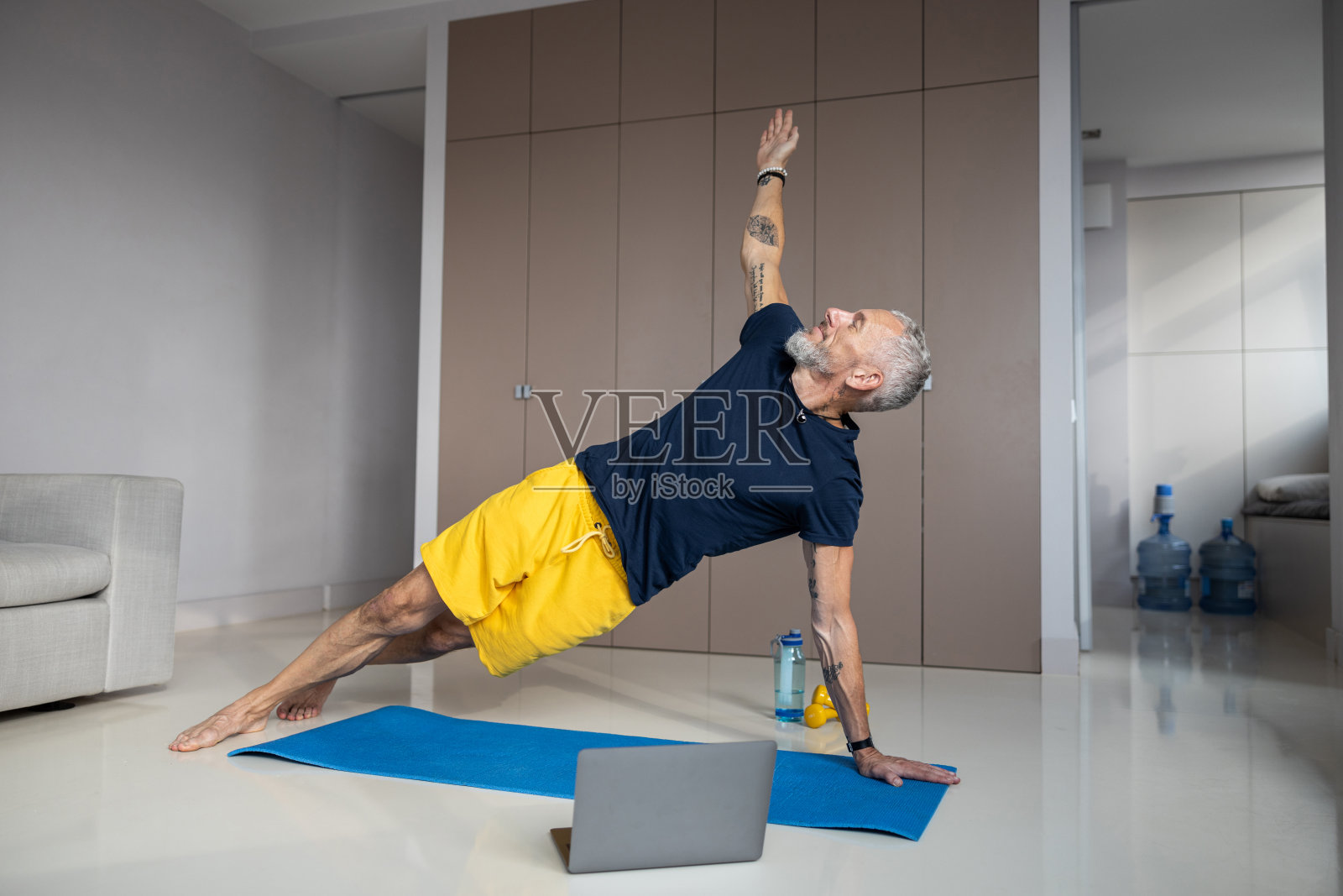 一个健康的男人在锻炼中做侧平板支撑照片摄影图片