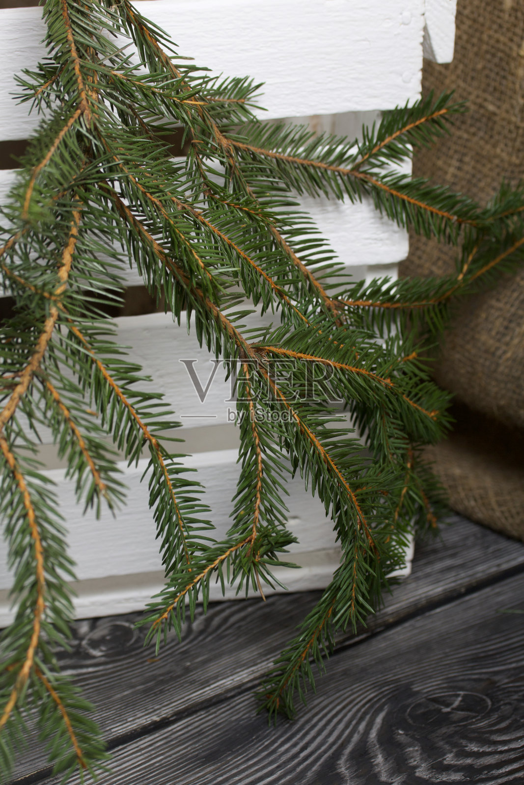 白松木板和粗糙的亚麻布映衬着冷杉树枝。照片摄影图片