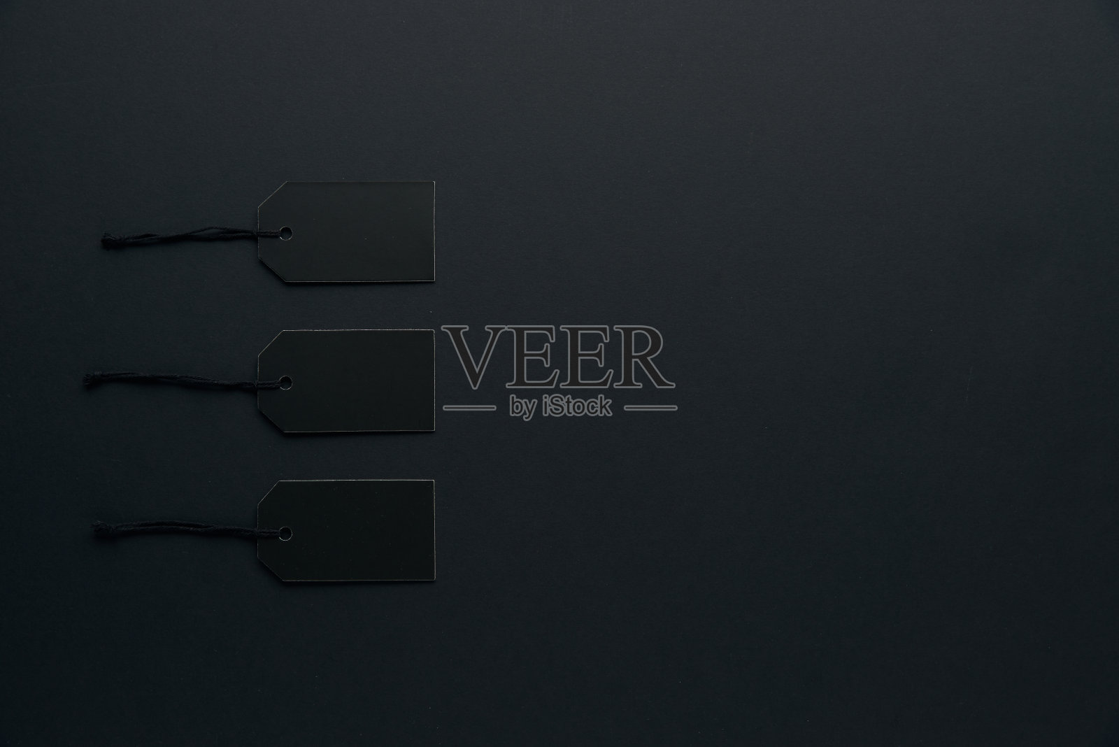 空白黑色硬纸板纸标签或价格标签与电线隔离在黑暗的背景。BlackÂ周五，购物，销售和营销的概念。顶视图,平,复制空间照片摄影图片