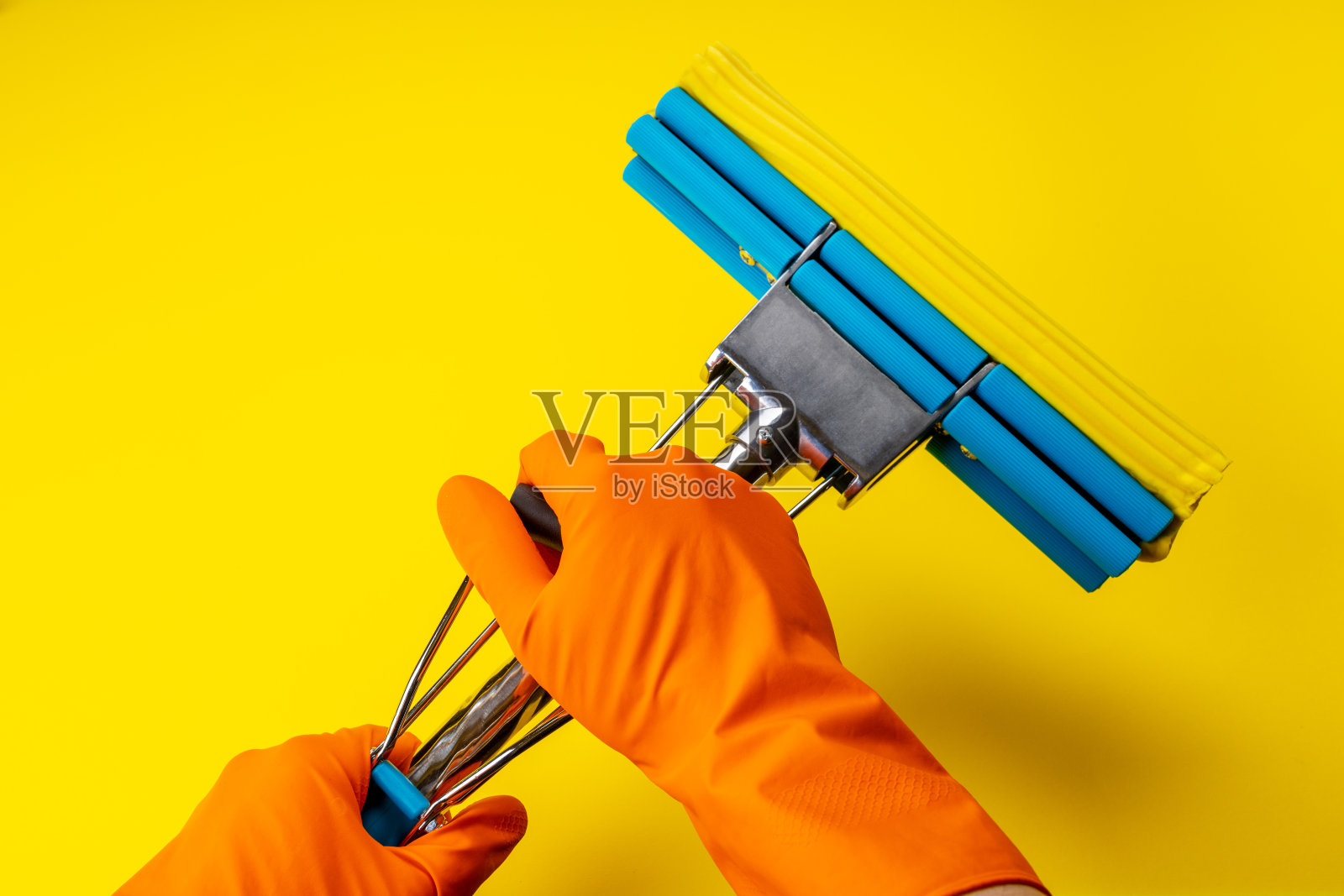 海绵拖把和其他清洁用品隔离在黄色背景上。以上的观点。影棚拍摄。清洁和清洁概念照片摄影图片