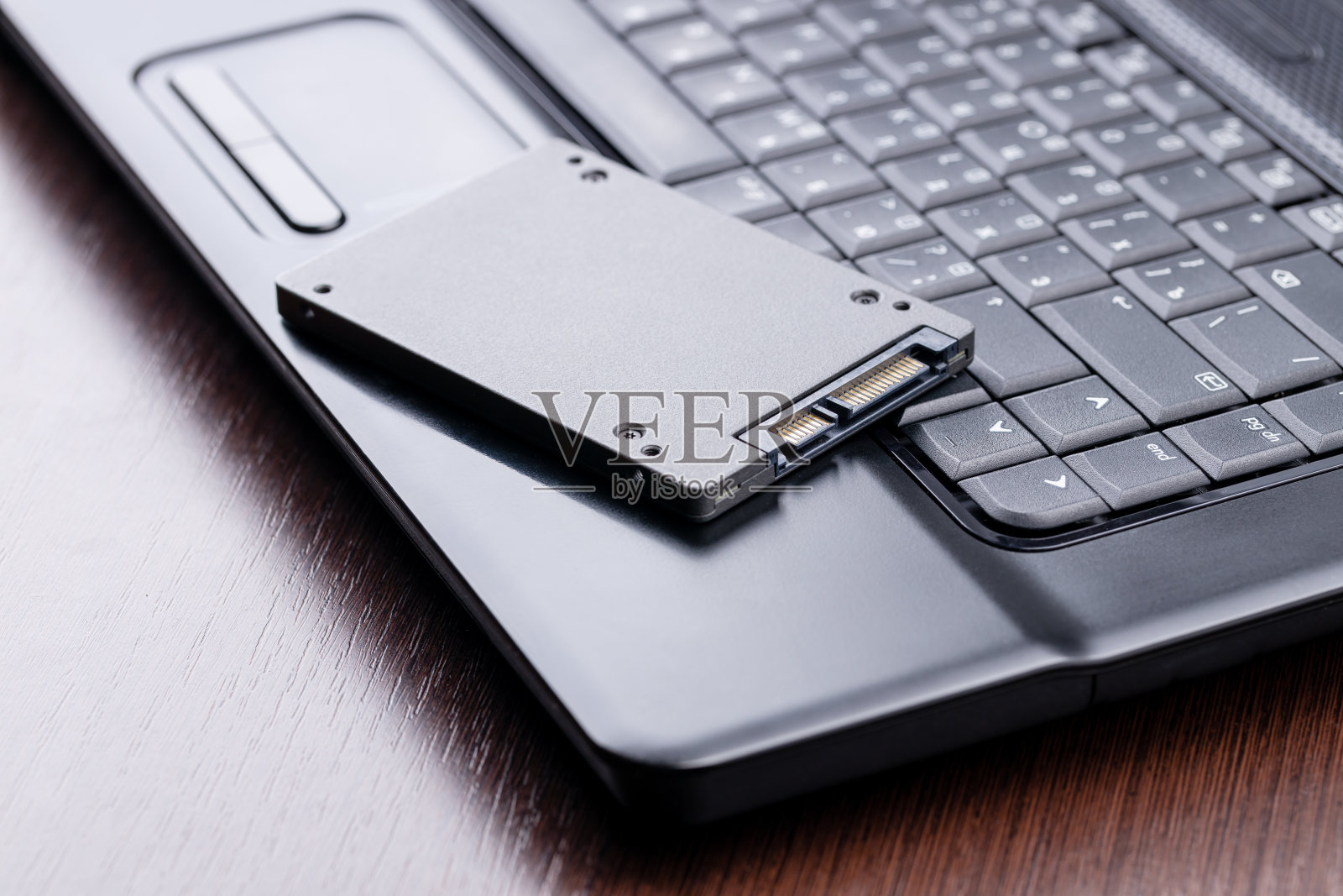 维修和升级笔记本电脑。笔记本电脑上的新固态硬盘。电脑维修服务理念。笔记本电脑存储系统故障照片摄影图片