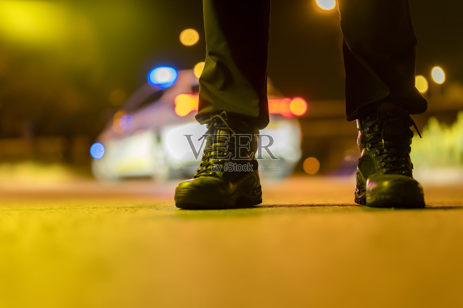 特写的警察靴子和汽车在背景照片摄影图片