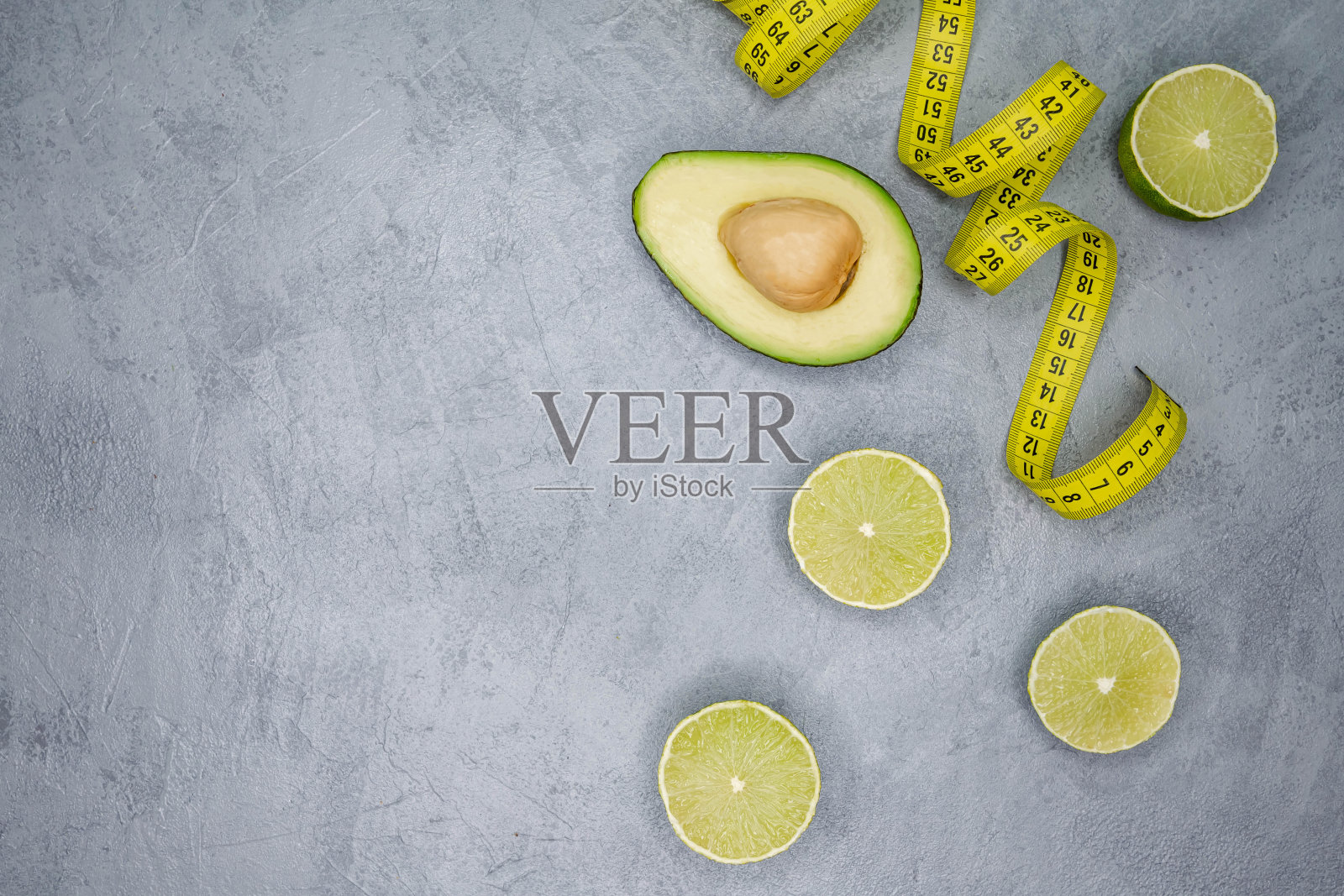 生牛油果的一半与卷尺在灰色背景。超级食物的饮食照片摄影图片