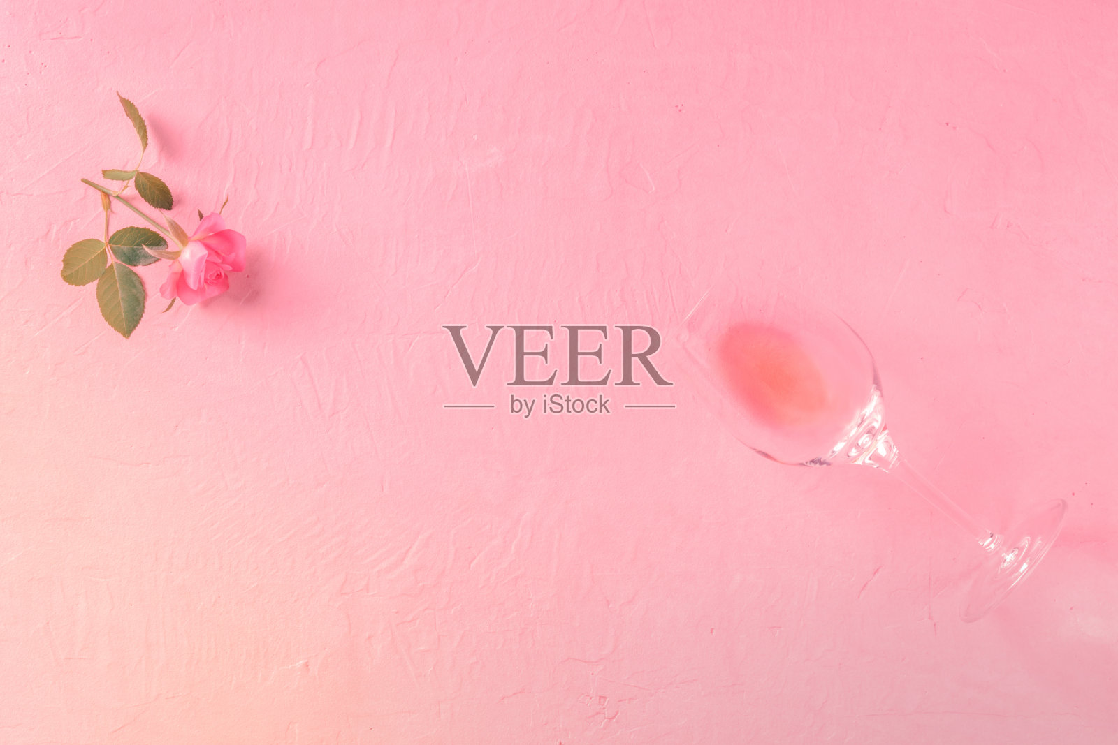 浪漫的邀请模板用一杯玫瑰酒和一朵粉红色的花，上端拍，平躺着放文字的地方照片摄影图片