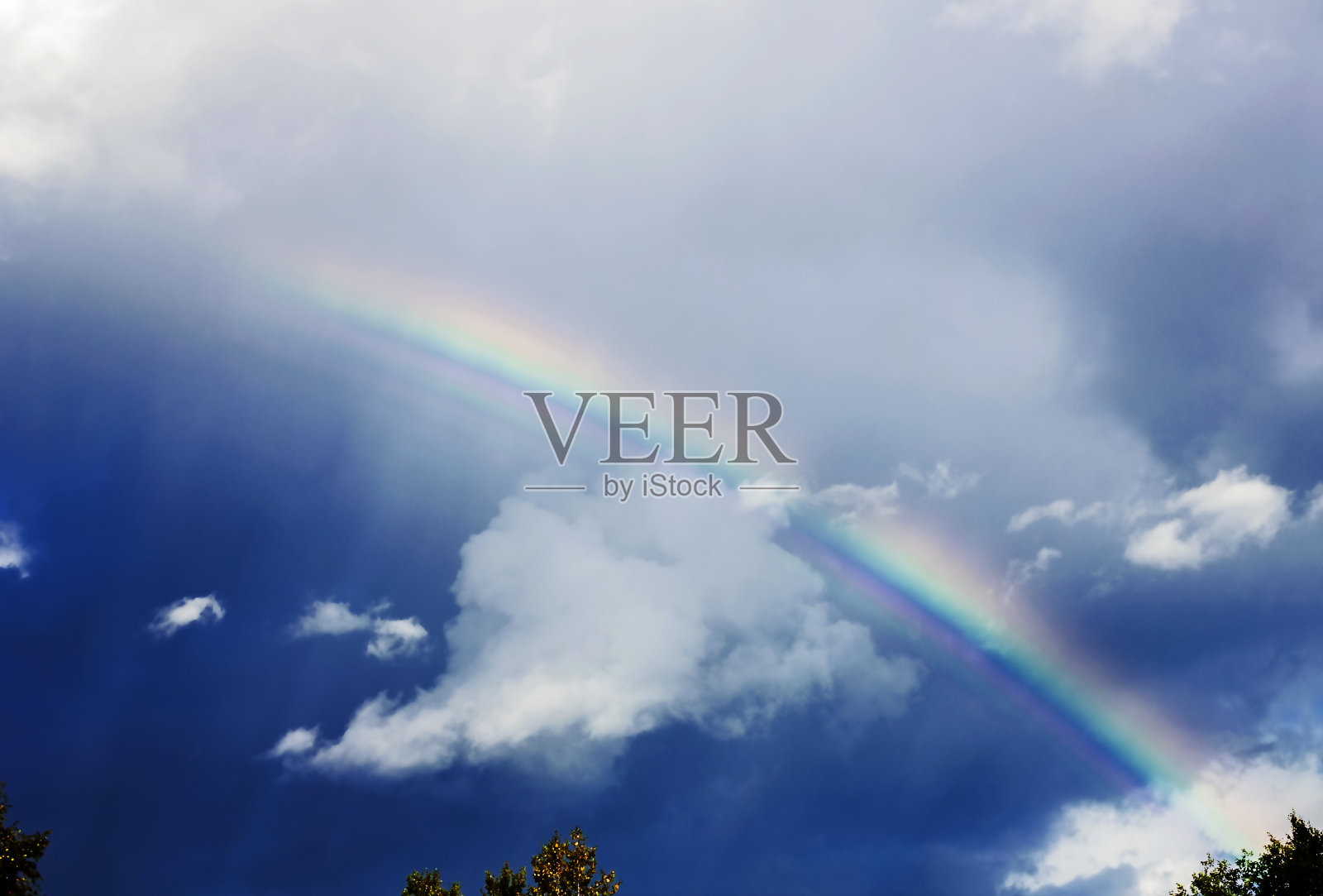 彩虹在黑暗的天空透过白云照片摄影图片