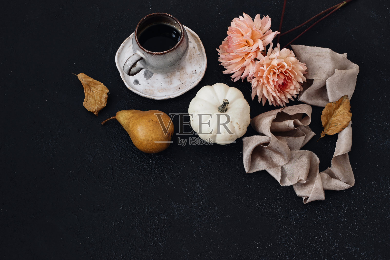 秋静物作文。一杯咖啡，梨子水果，白色南瓜和粉红色的大丽花。黑色表背景。山毛榉的叶子。穆迪秋天，感恩设计。平躺，俯视图。照片摄影图片