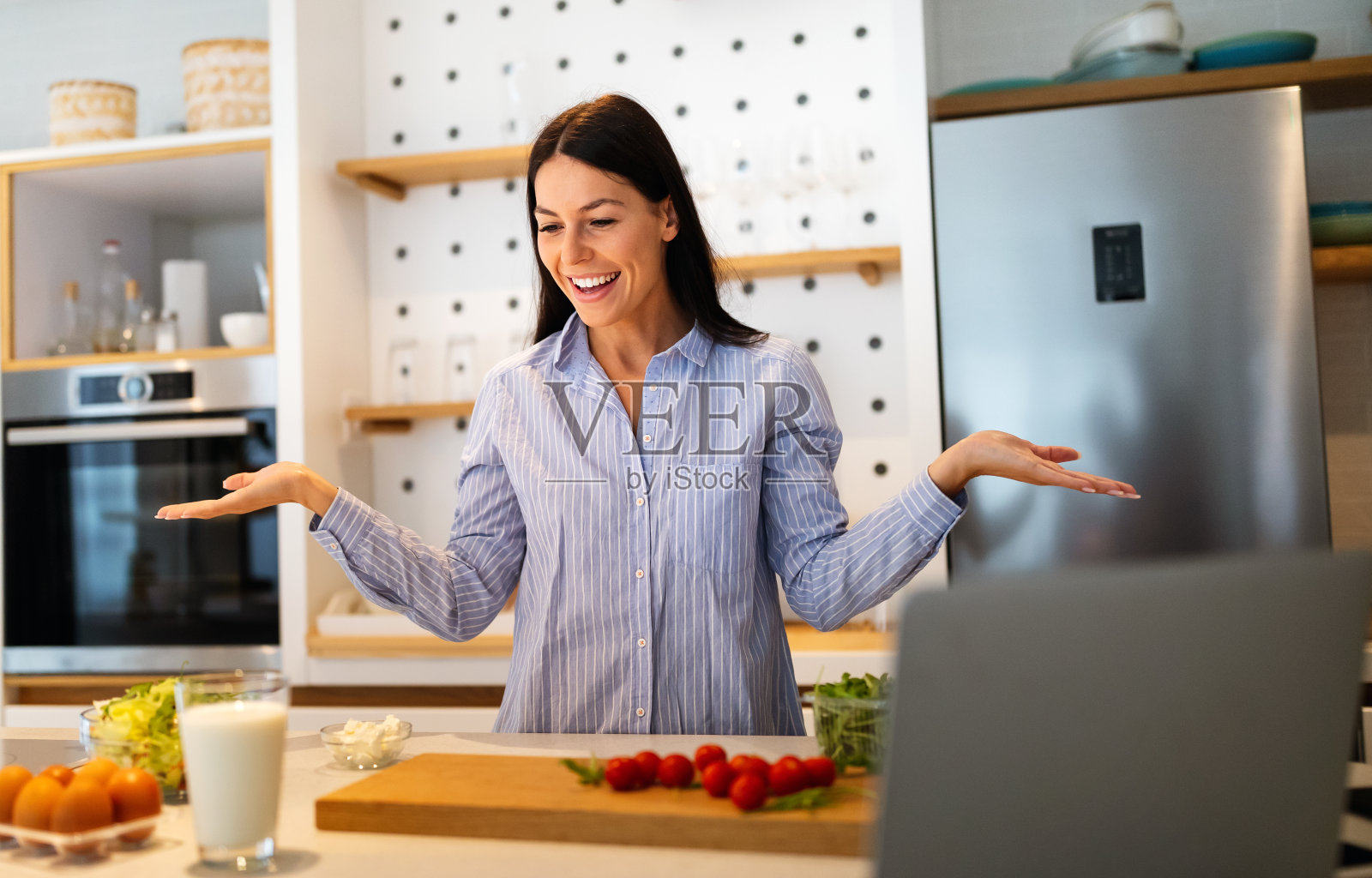 美丽的年轻女子正在厨房里准备食物。健康饮食理念照片摄影图片