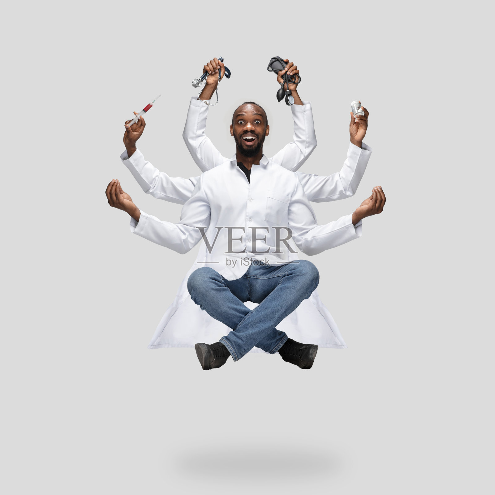 英俊的多臂医生悬浮孤立在灰色工作室背景与设备照片摄影图片