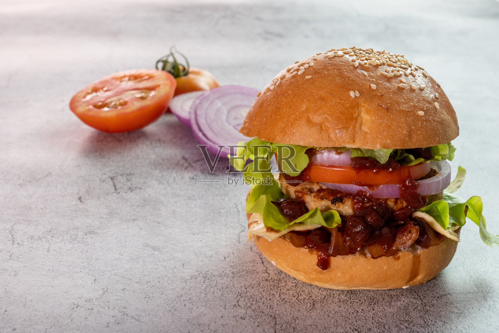 汉堡，汉堡，芝士汉堡，在面包与生菜，番茄，洋葱，培根，美味的快餐，在水泥地板的背景。照片摄影图片