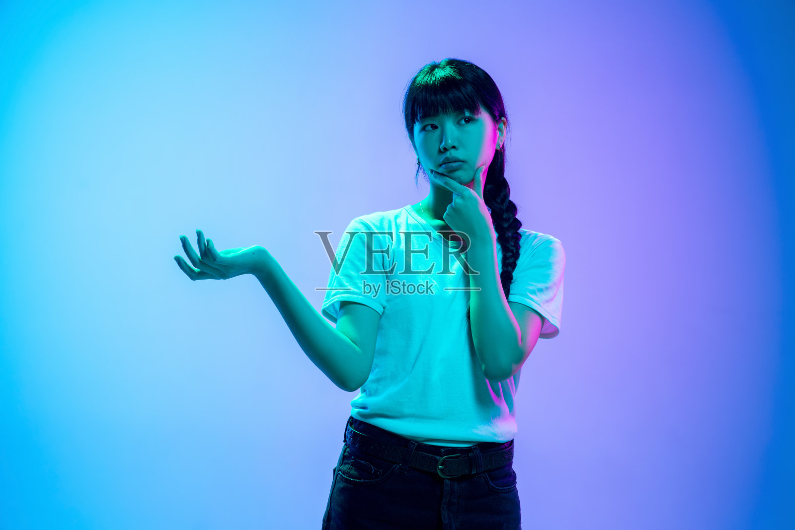 年轻的亚洲女人的肖像在渐变蓝紫色的工作室背景霓虹灯照片摄影图片