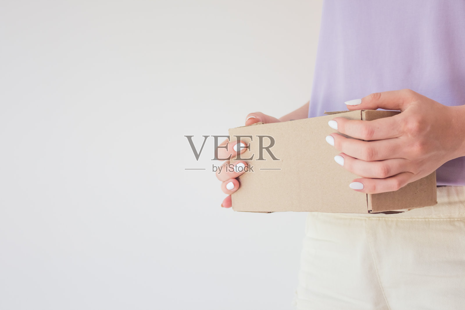 Сourier将包裹递送给收件人。满意的收件人手里拿着包裹的硬纸盒。交货时间的概念，快速交货照片摄影图片