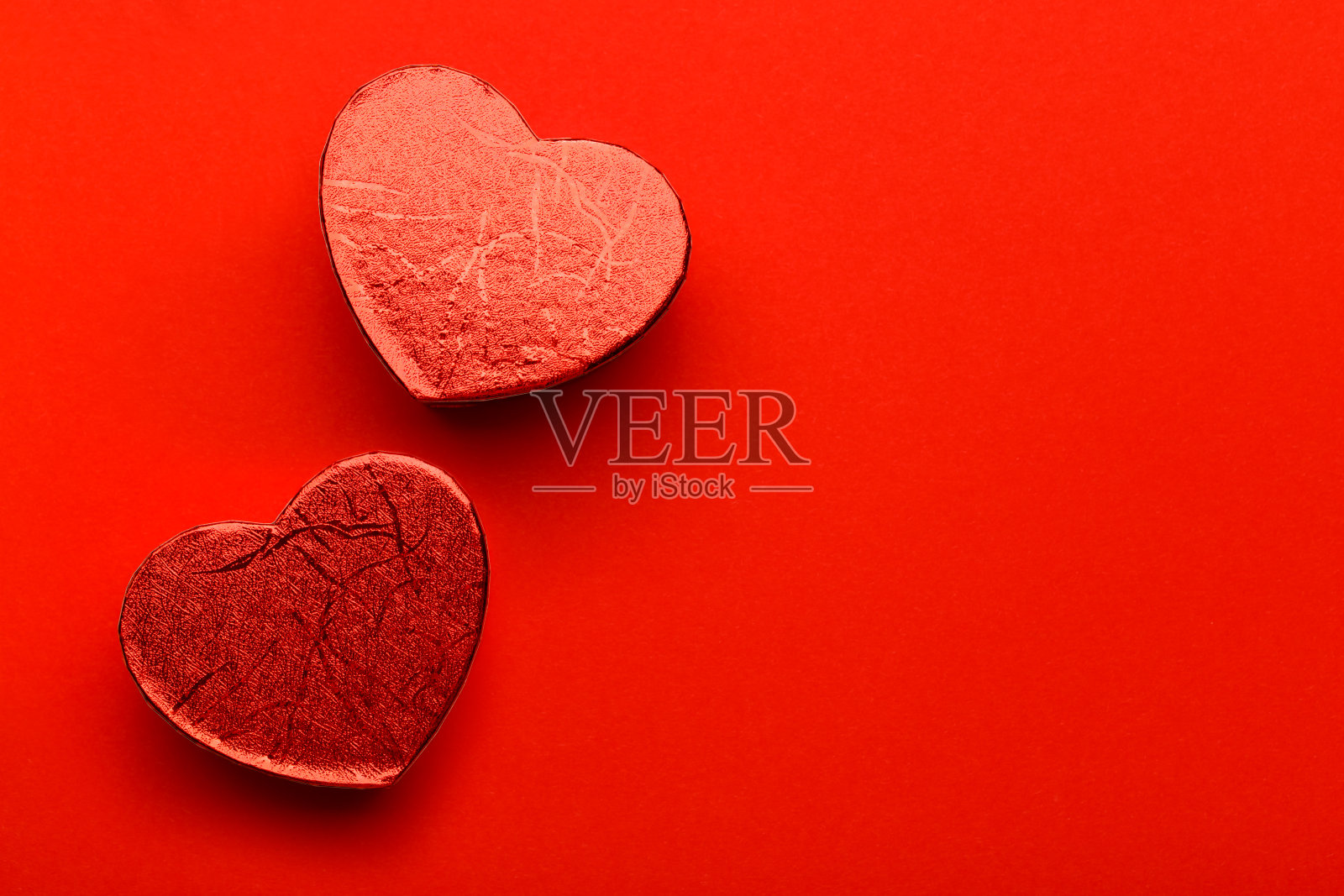 两颗心在红色背景与复制空间。照片摄影图片