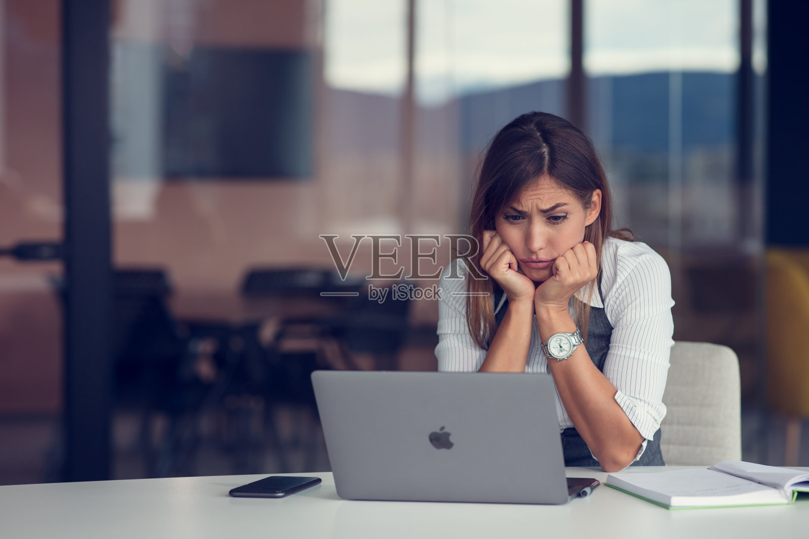 在现代化的办公室里，愤怒的女商人正在打电话照片摄影图片