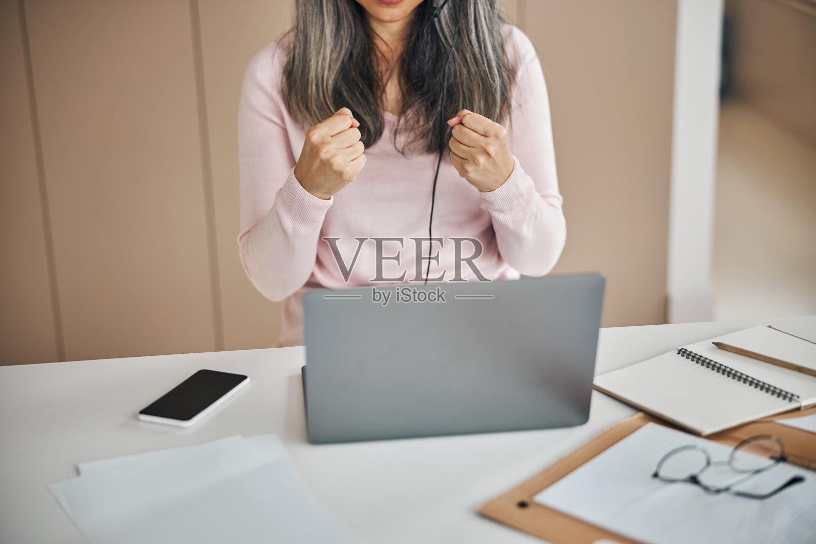 美丽的女性坐在桌子上，而学习视频通话照片摄影图片