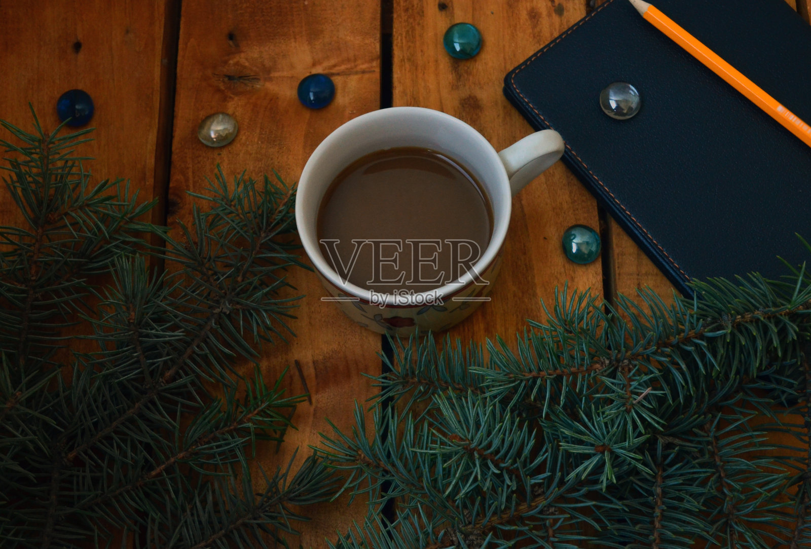 一个咖啡杯，一个黑色笔记本，一棵圣诞树和一支铅笔。办公用品，箱子，计划。照片摄影图片