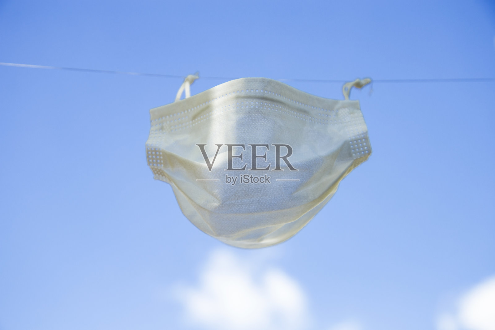 一个用绳子吊着的白色防护面罩照片摄影图片