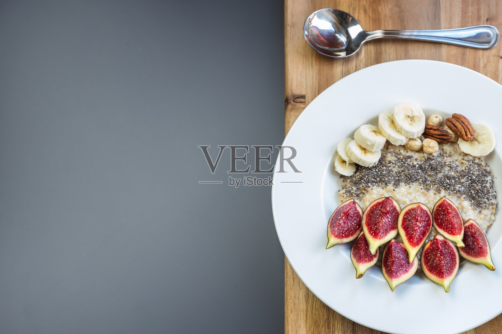 一碗早餐燕麦粥，上面有奇异子、新鲜无花果和香蕉照片摄影图片