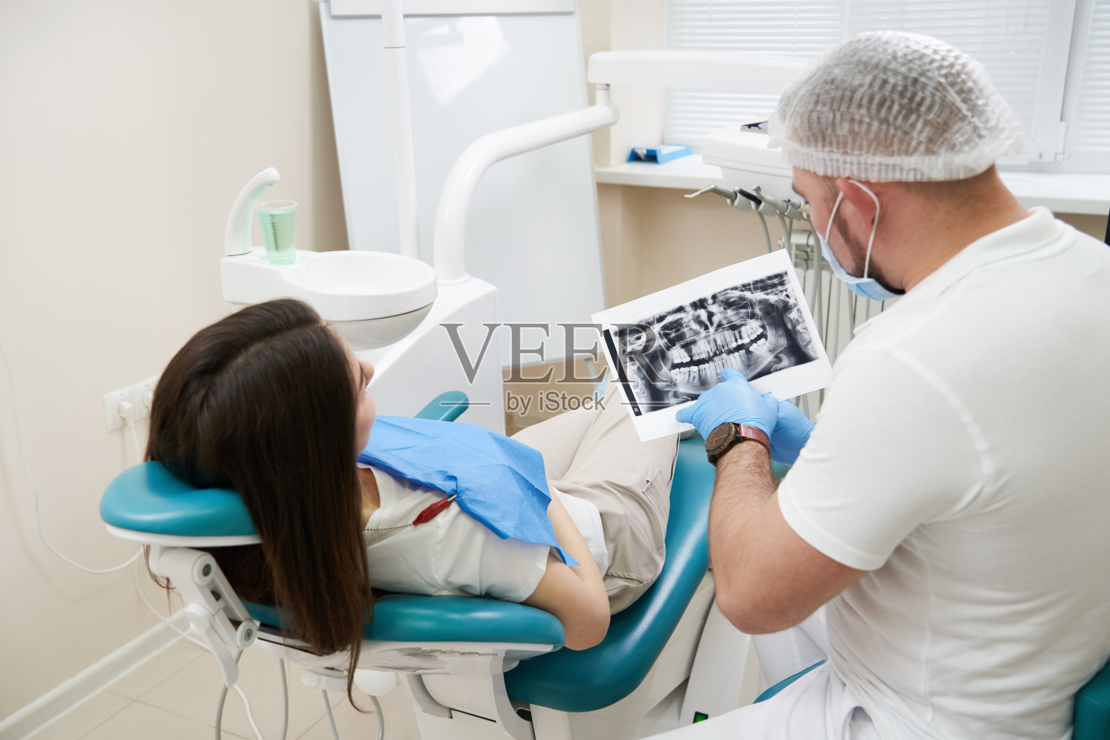 医生给病人看一张x光片。电脑诊断。牙科x线断层摄影术照片摄影图片