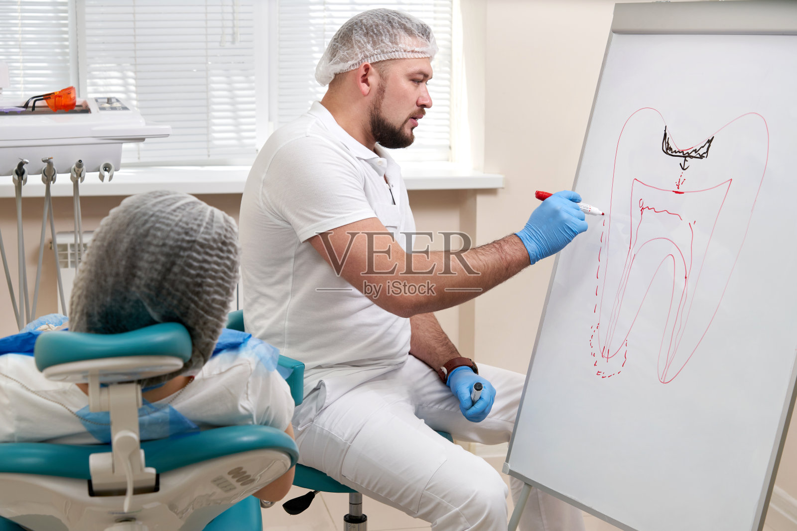 牙科医生在牙科诊所的白板上画牙齿照片摄影图片