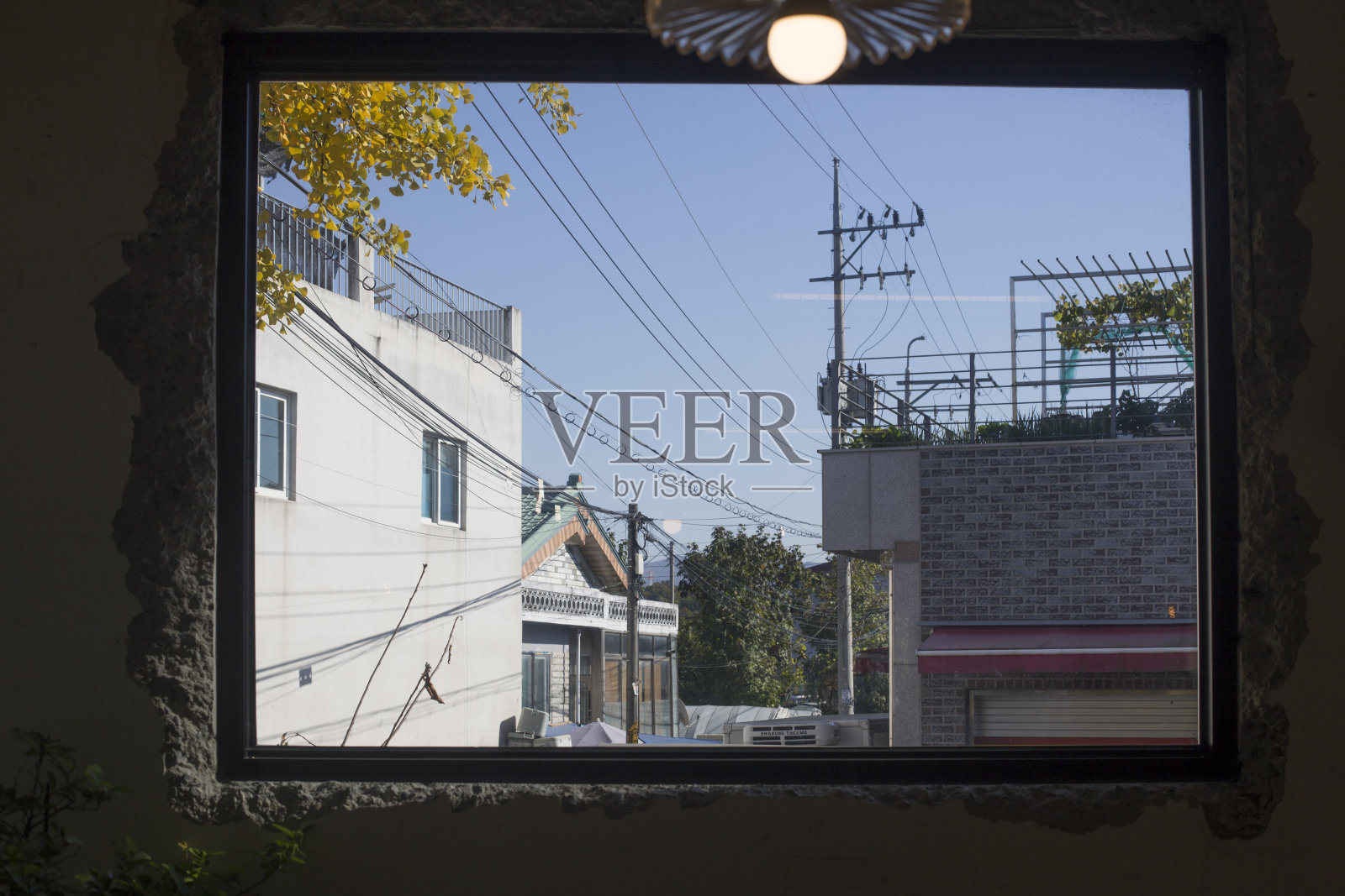 从混凝土窗框上看到的一个村庄。照片摄影图片