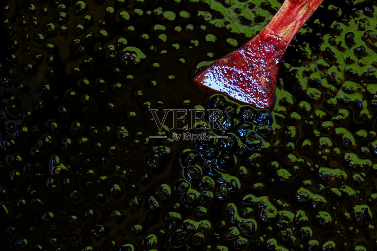 从上往下看秋莓果酱，在草莓的表面用一个木制的烹饪勺子。扎维德维奇，波斯尼亚和黑塞哥维那。照片摄影图片