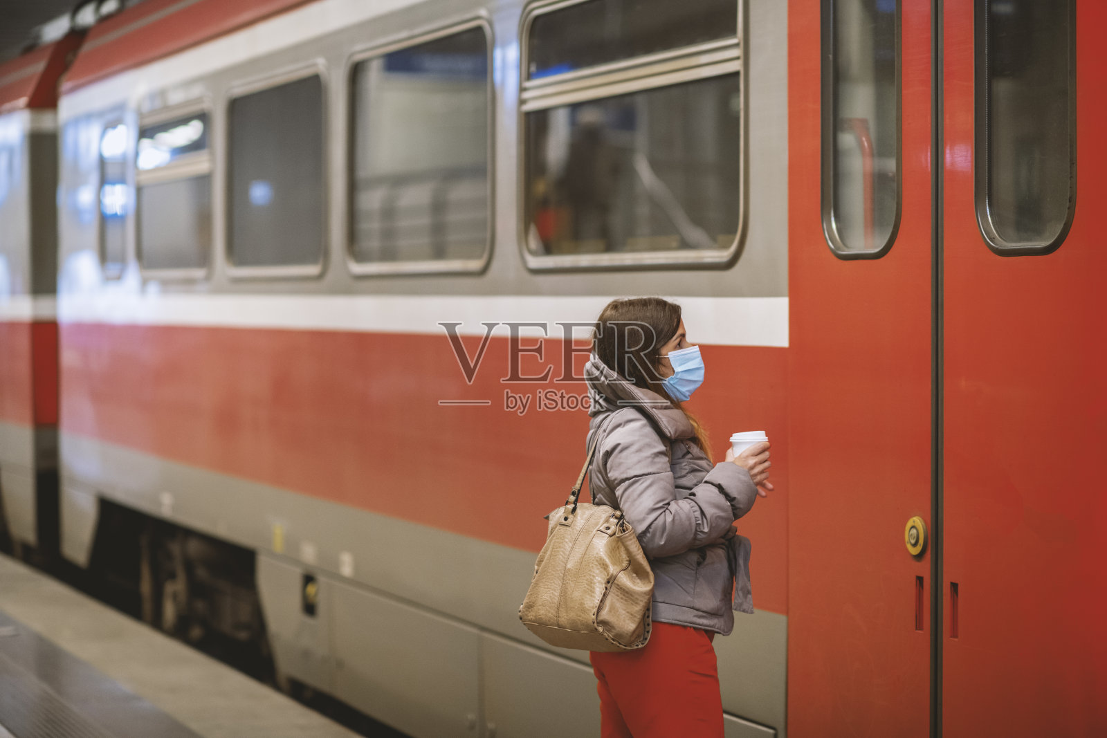 年轻女子戴着防护口罩等地铁照片摄影图片