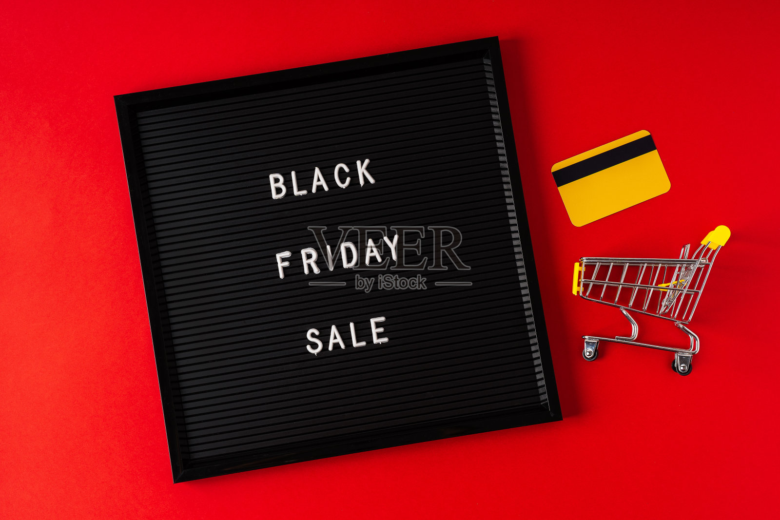 黑色的星期五在黑色的黑板，礼物，购物车和信用卡和红色的背景。概念季销售时间。平放俯视图复制空间模板布局为您的设计。照片摄影图片