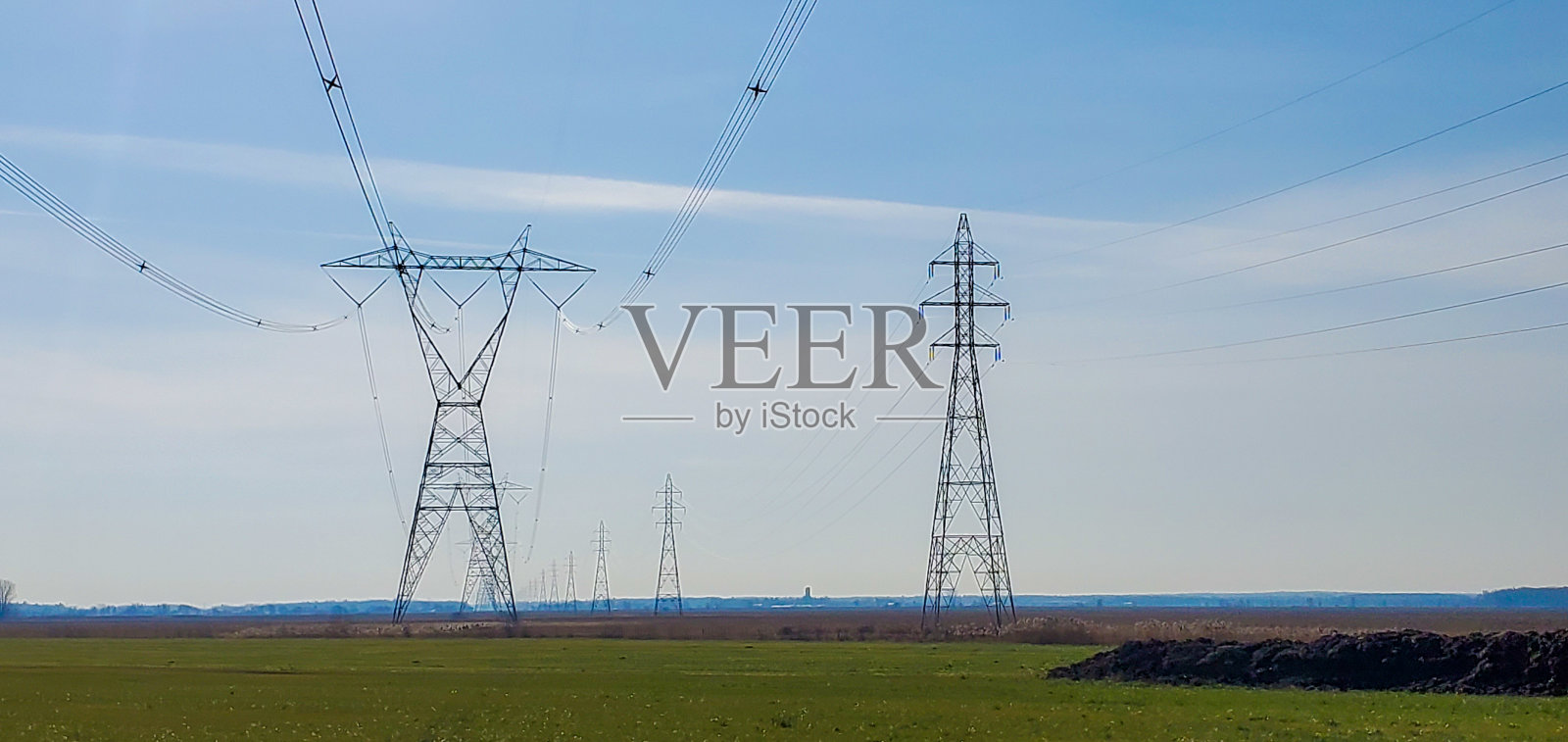 用电塔翻耕后的农田照片摄影图片