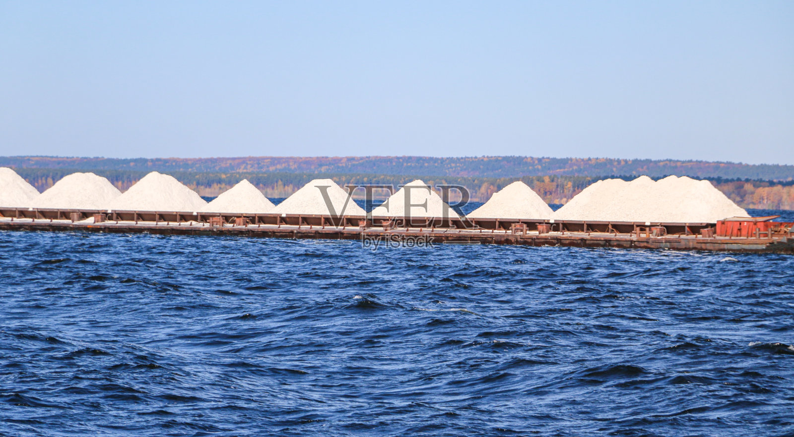 工业商船在风暴前的小浪中航行。装载货物的船只前往交货地点。照片摄影图片