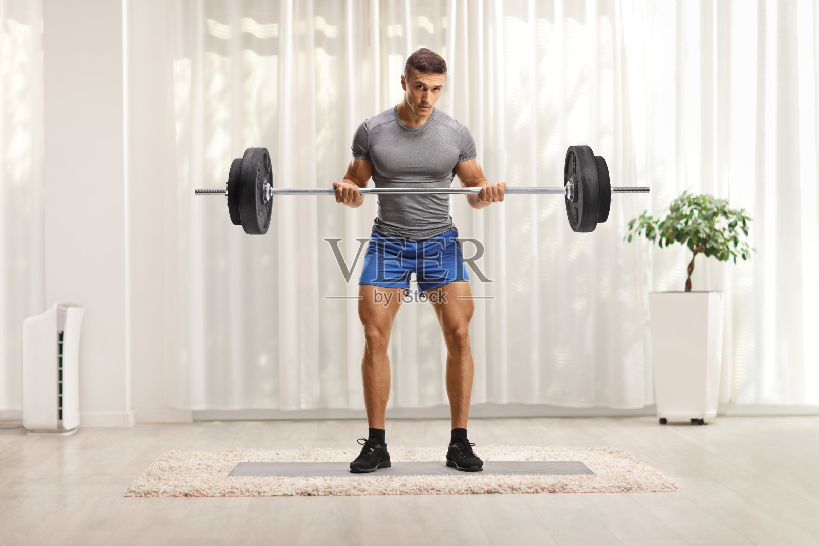 一个健美运动员在家里举重的全身像照片摄影图片