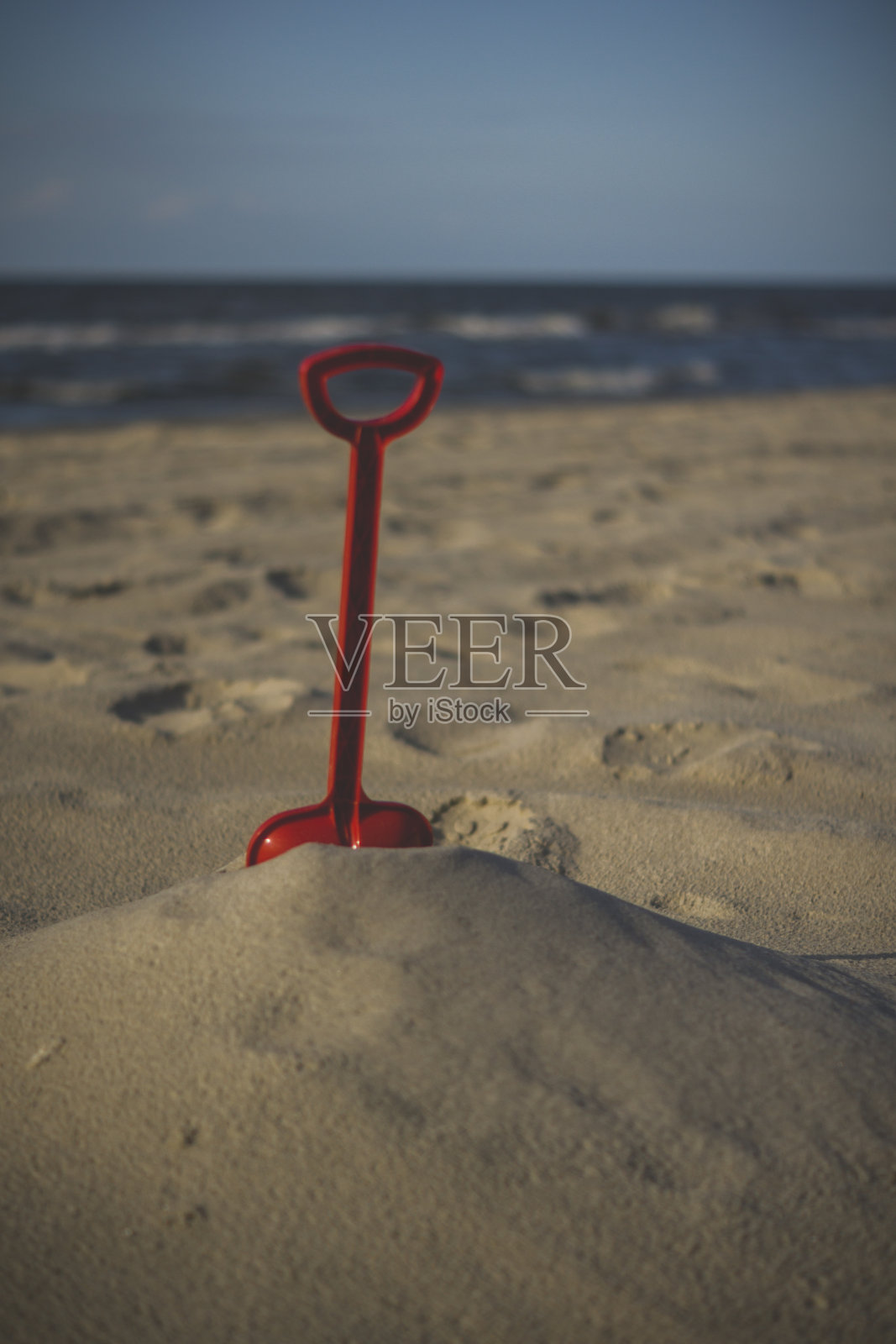 红色塑料砂铲在沙滩上照片摄影图片