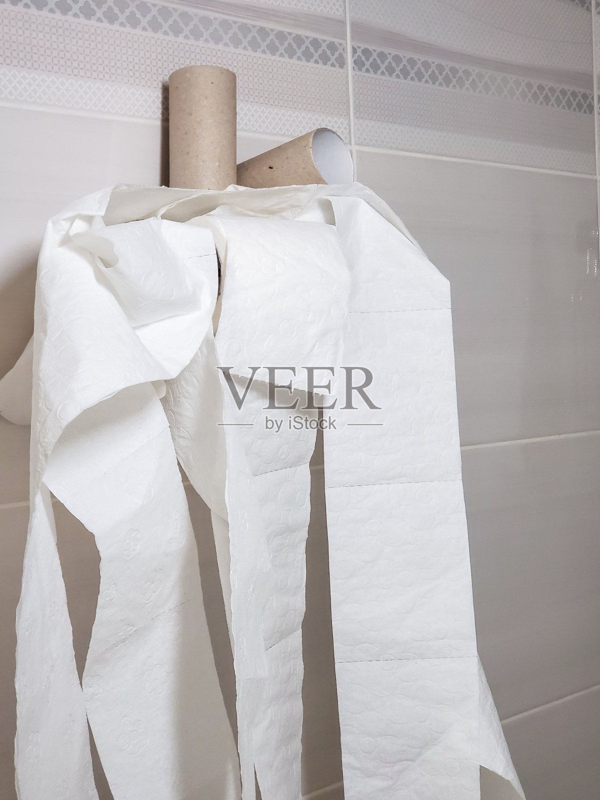 白色软厕纸被随意地展开，挂在一个镀铬的支架上照片摄影图片