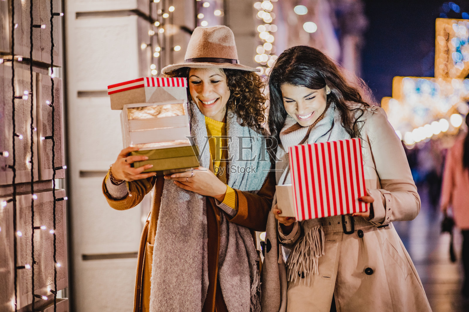 两个兴奋的女性朋友拿着圣诞礼物照片摄影图片