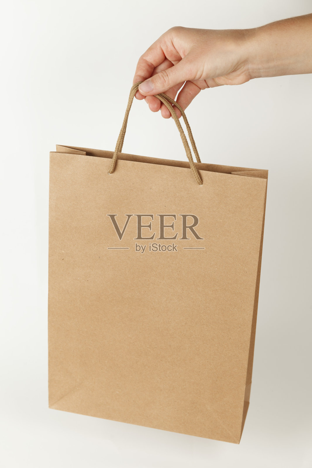 白色背景上的棕色再生纸袋。模型与复制空间的文本照片摄影图片