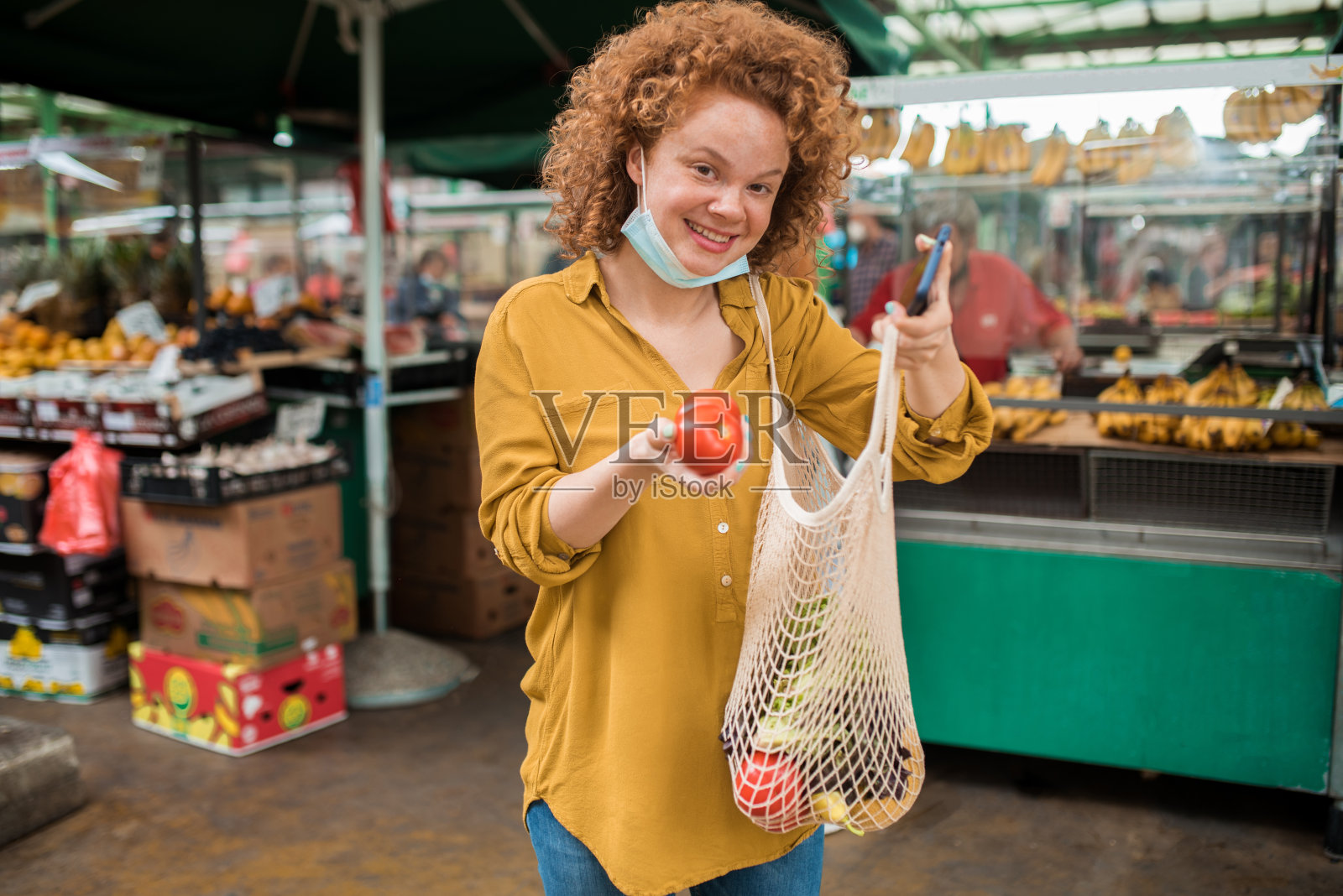 一个快乐的女孩在市场上买新鲜蔬菜的肖像照片摄影图片