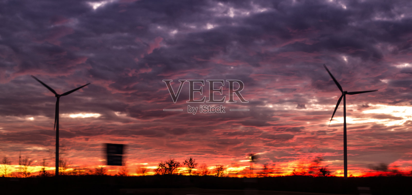 红色天空映衬着风力涡轮机的黑色剪影照片摄影图片