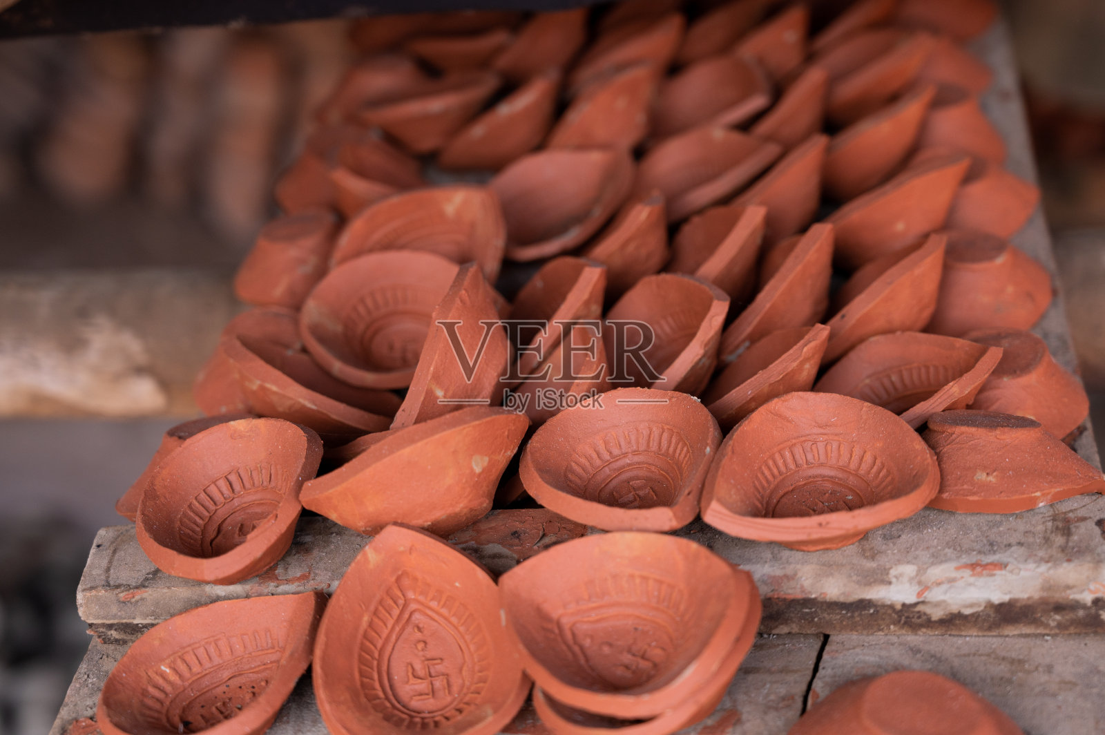 传统的diya是在印度农村的工厂里用泥土和泥土在阳光下制成的。照片摄影图片