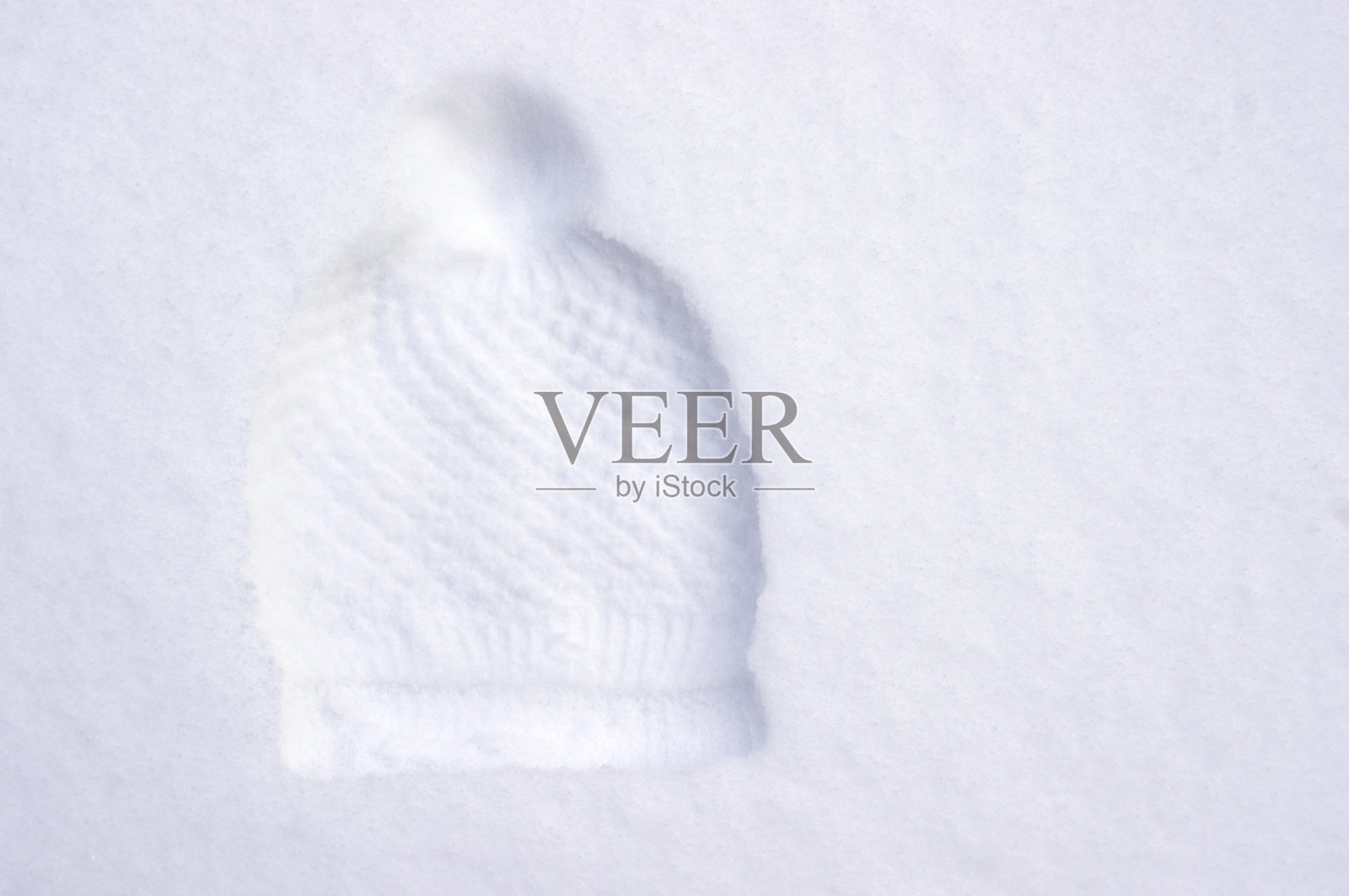 冬季帽子与绒球印在白色的雪照片摄影图片