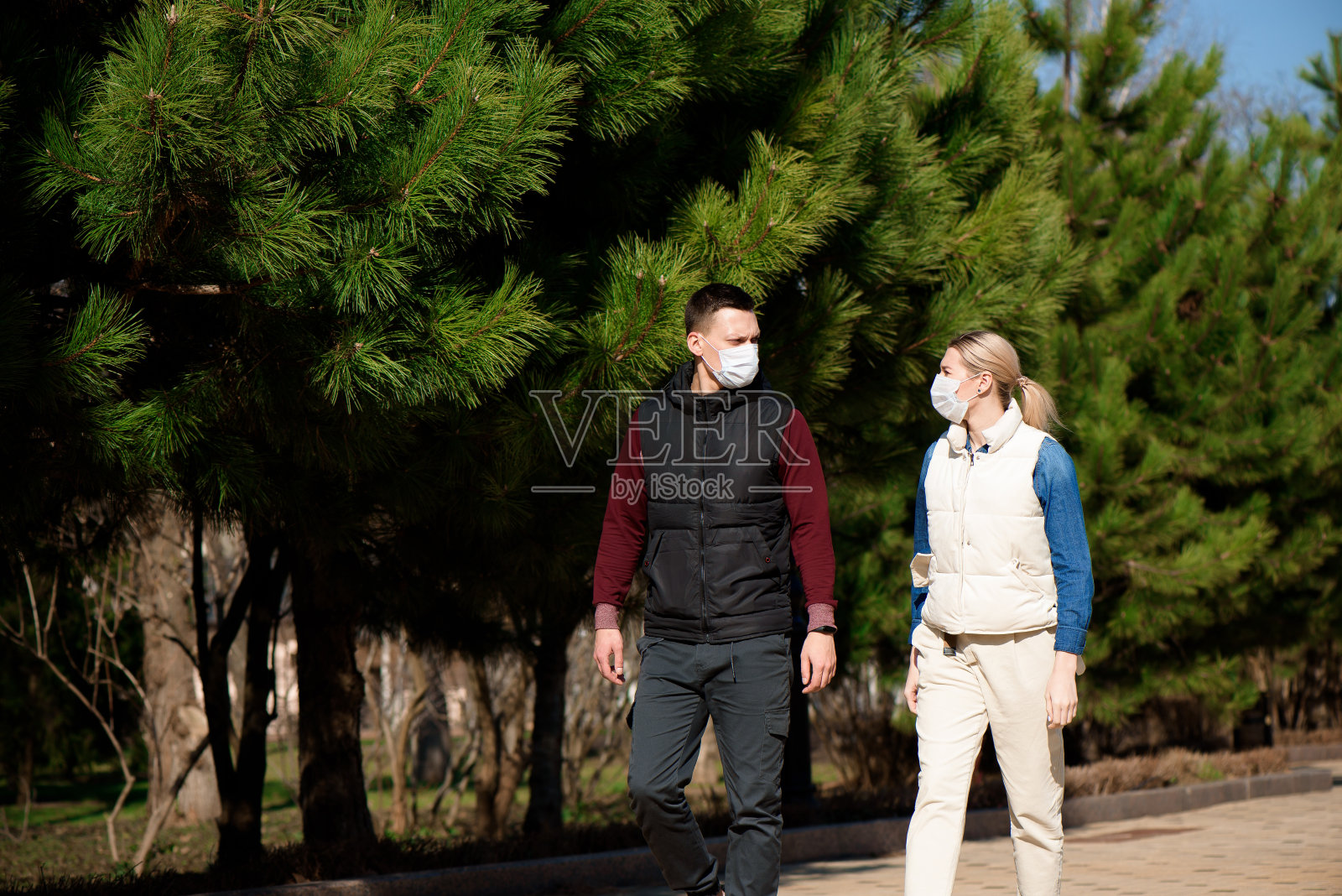 欧洲青年男女戴一次性医用防护口罩外出，害怕新型冠状病毒(NCoV)在变异和传播照片摄影图片