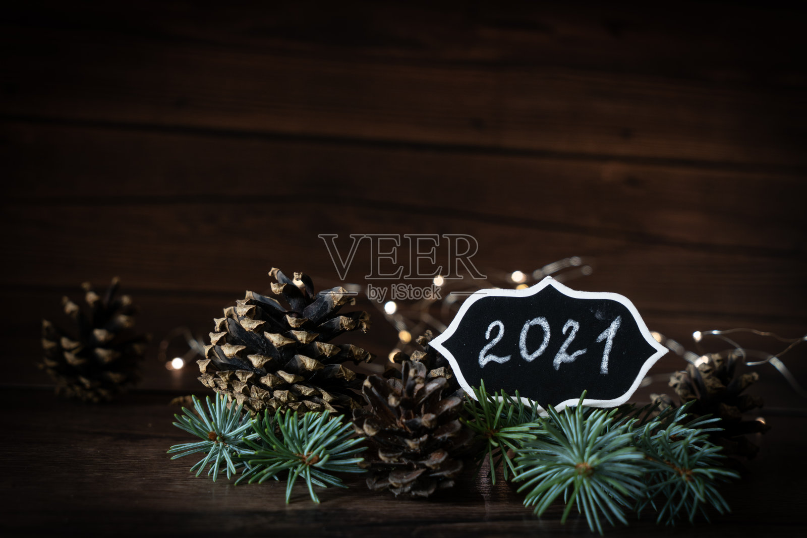 2021年新年前夕散景，松果组成与文本模拟晚上黑暗手电筒，圣诞树灯照片摄影图片