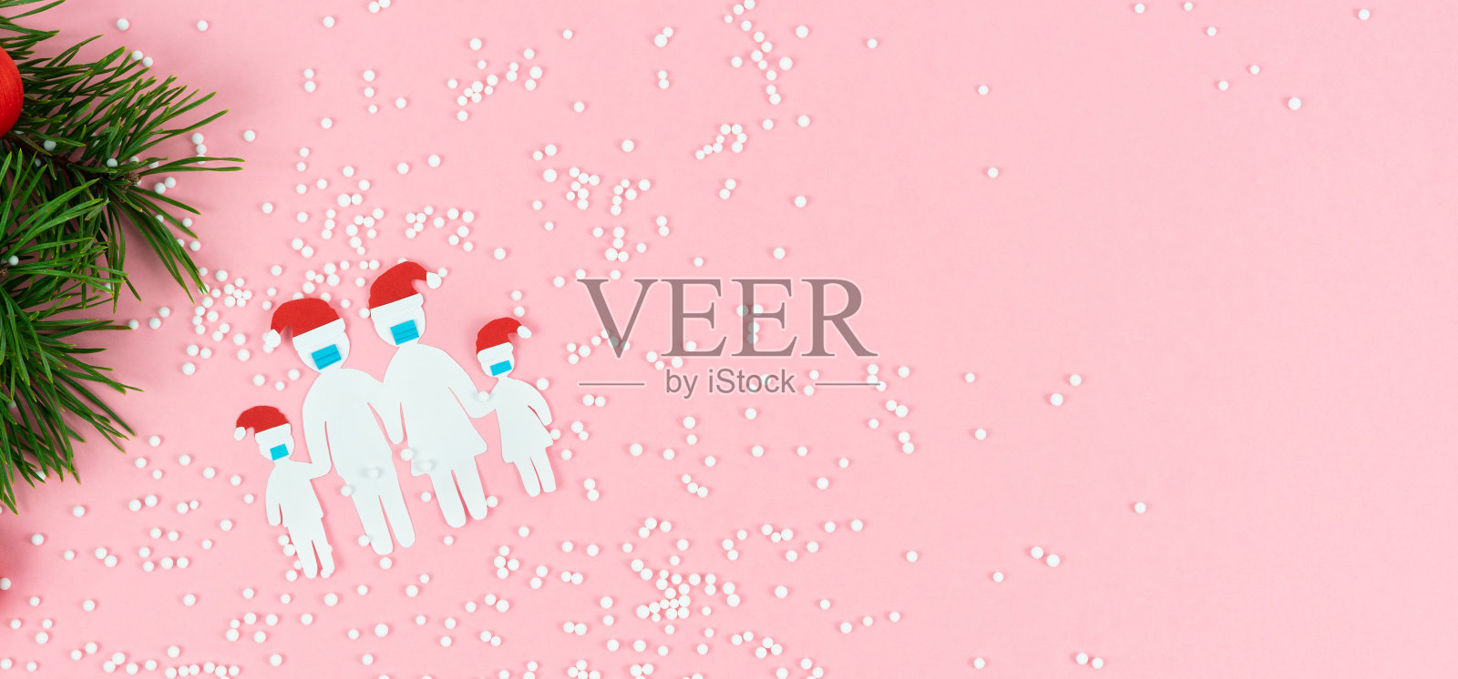 剪纸家庭面具和圣诞帽在一个粉红色的背景与圣诞装饰。插画图片素材