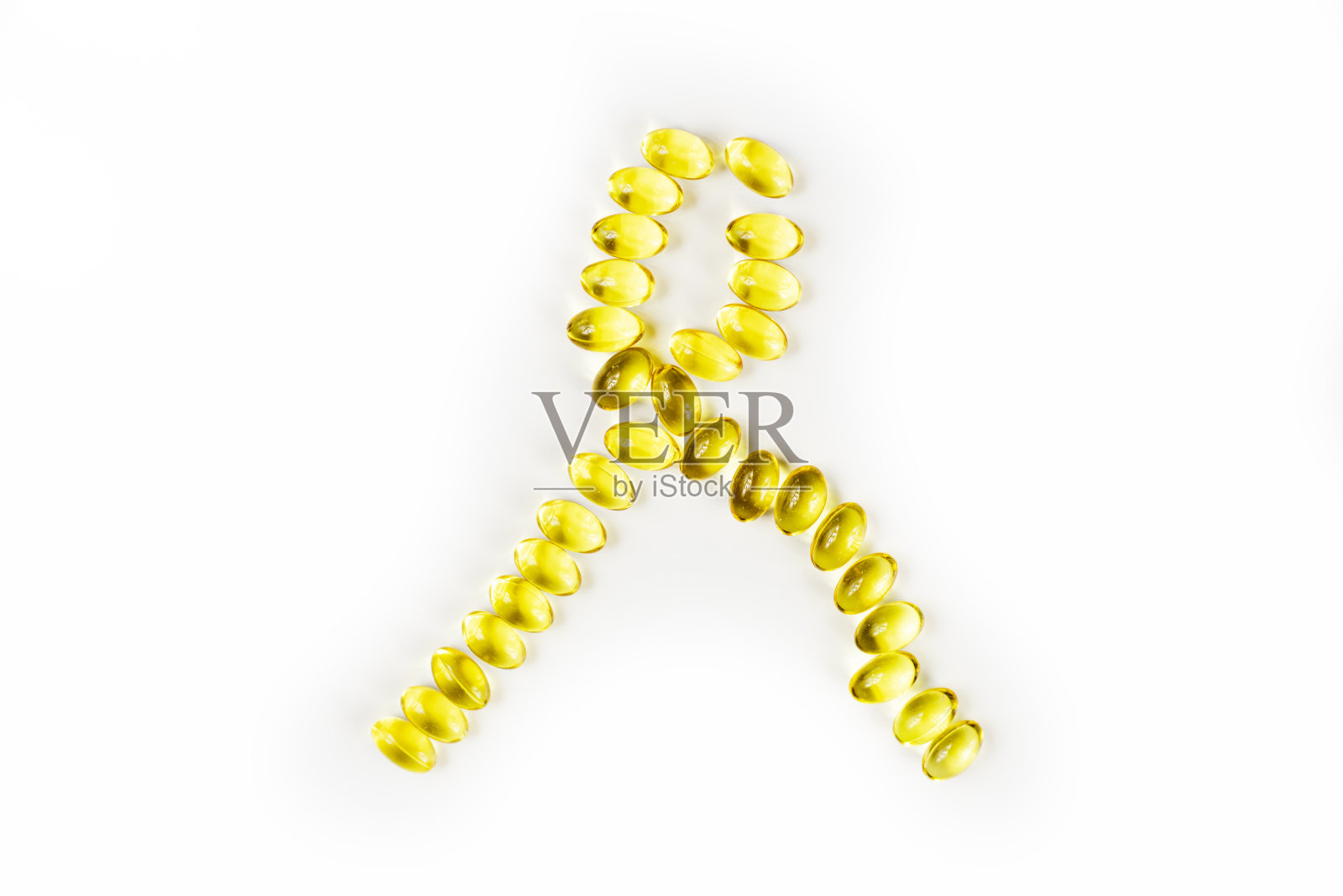 象征性的鱼油胶囊缎带上白色背景，黄色缎带，横放照片摄影图片