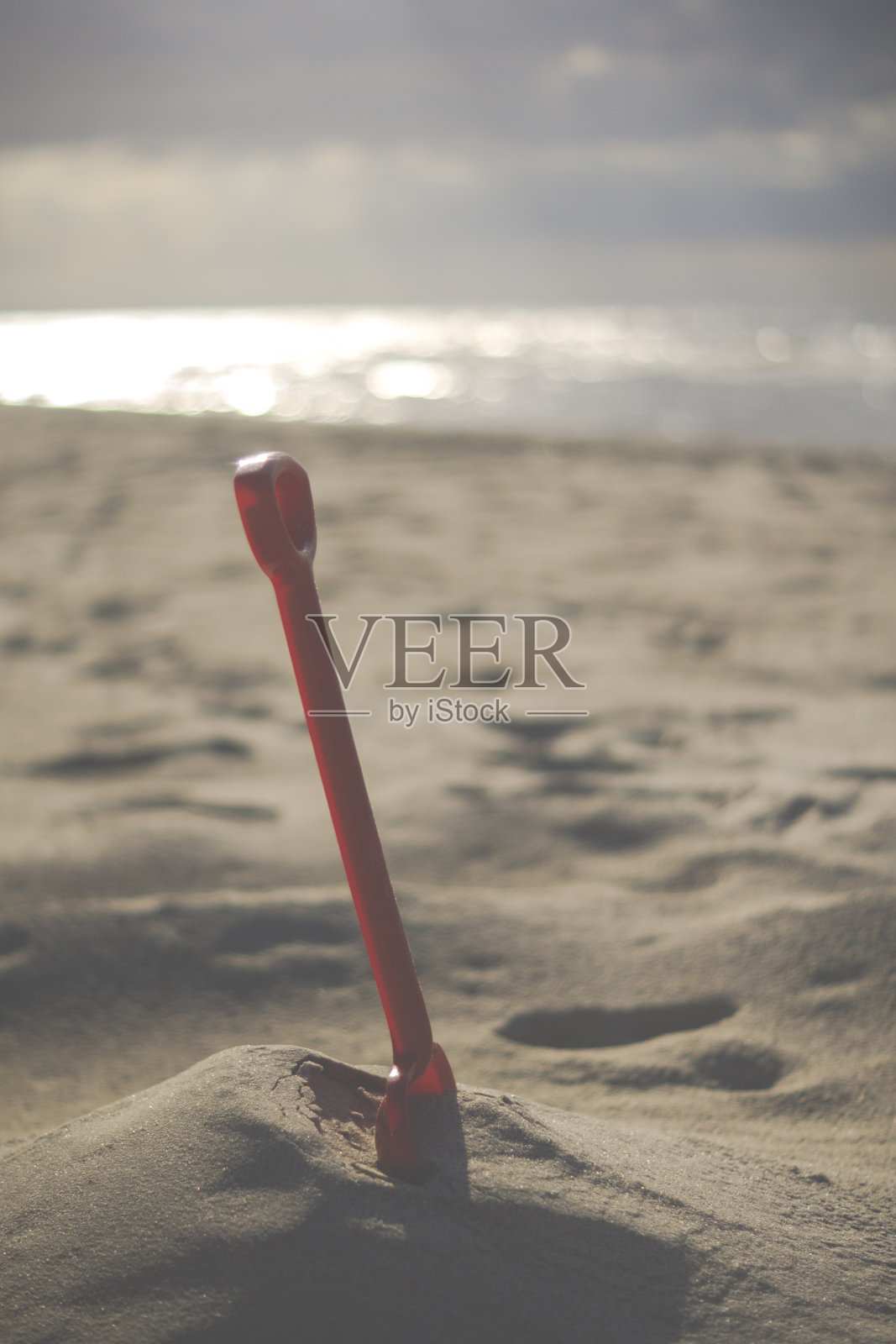 红色塑料砂铲在沙滩上照片摄影图片