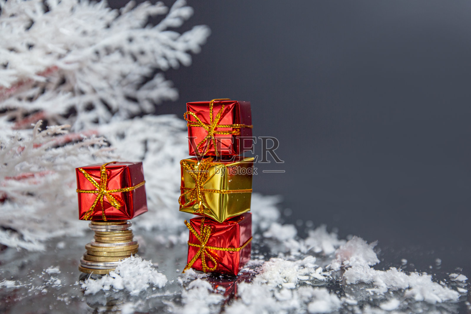 硬币，圣诞球，灰色模糊背景上的小礼物，圣诞装饰照片摄影图片