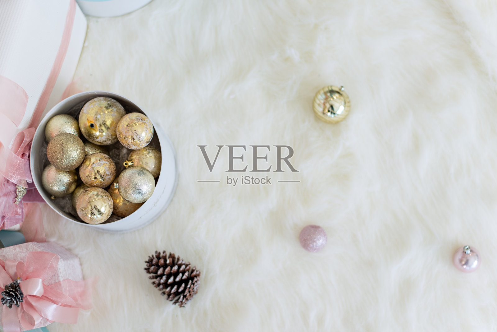 新年贺卡。白雪覆盖的圣诞树上，挂满了玻璃玩具、粉色球、水晶和彩灯花环，上面放着圣诞老人送的礼物。副本的空间。照片摄影图片